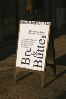 Light cream outdoor A-frame sign with wooden edges, Bread & Butter text on pavement