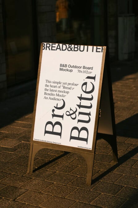 Light cream outdoor A-frame sign with wooden edges, Bread & Butter text on pavement