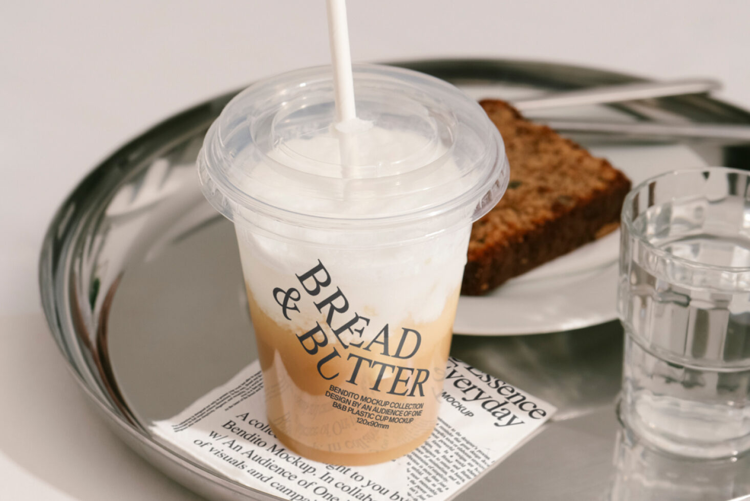 Coffee cup mockup with Bread and Butter branding on a tray next to water and bread; ideal for beverage packaging design and marketing presentations.