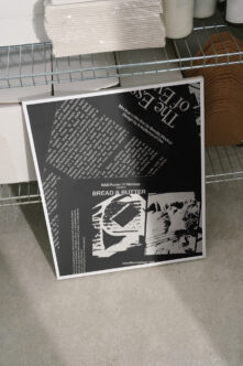 Overhead shot of black B&B Poster 01 40x60cm mockup on industrial metal shelf setting
