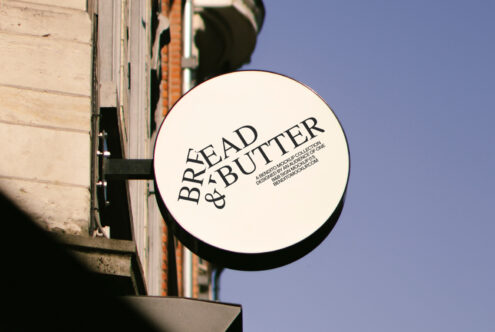 Round shop sign mockup displaying Bread and Butter text, perfect for storefront branding designs. Ideal for graphic and template designers seeking realistic visuals.