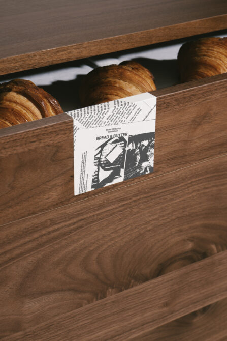 White sticker mockup on wooden bakery display with fresh croissants