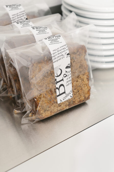 Clear plastic food packages with white sticker labels showing Bread Butter branding
