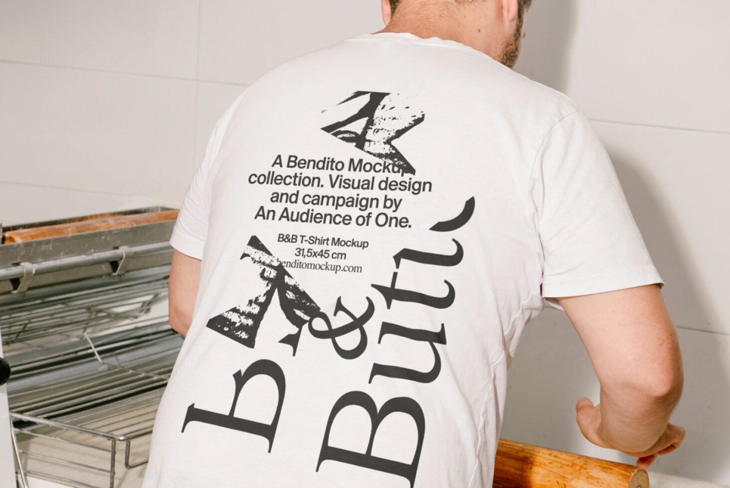 Man wearing a graphic t-shirt featuring a unique typography design from Bendito Mockup. Suitable for mockup showcases and visual design projects.