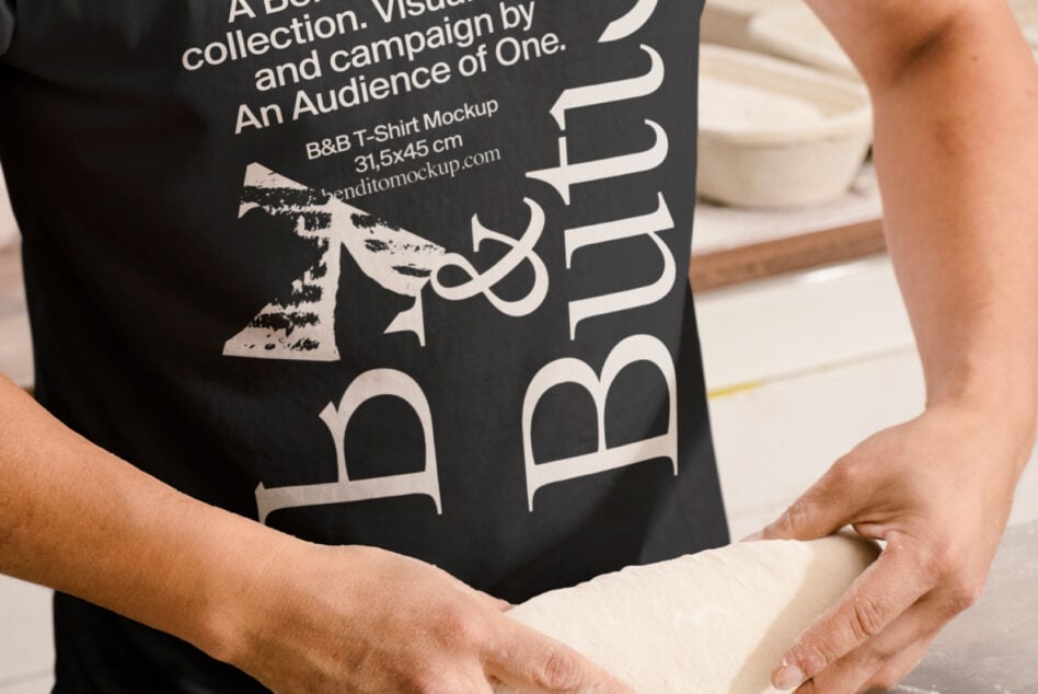 Close up of B&B Butito graphic on black shirt, holding dough beside