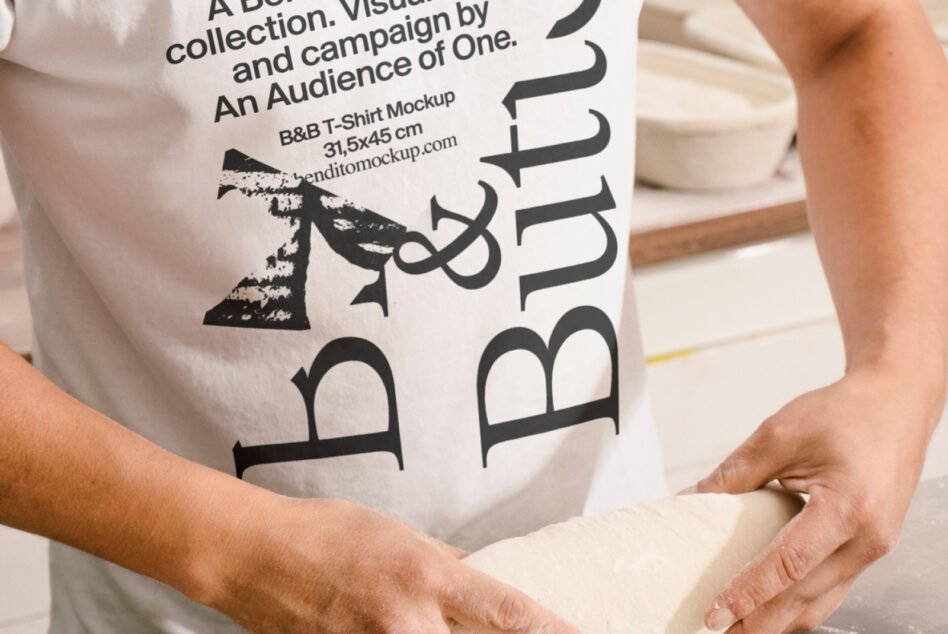 Close up of B&B Butito graphic on white shirt, holding dough beside