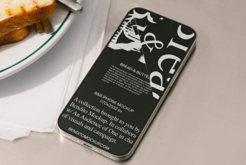 iPhone mockup with bold typography on screen beside bread on a plate. Ideal for showcasing font designs in high-quality graphic presentations for designers.