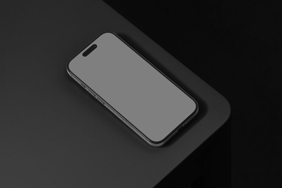 iPhone 14 mockup on angled dark surface, landscape orientation