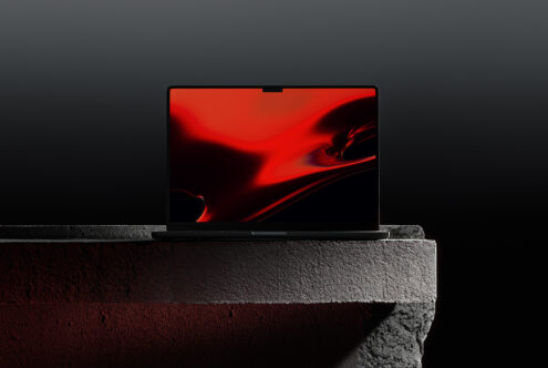 Laptop mockup with vibrant red screen on dark stone surface. Ideal for showcasing digital designs. Keywords: Mockup, Laptop, Red, Design, Template.