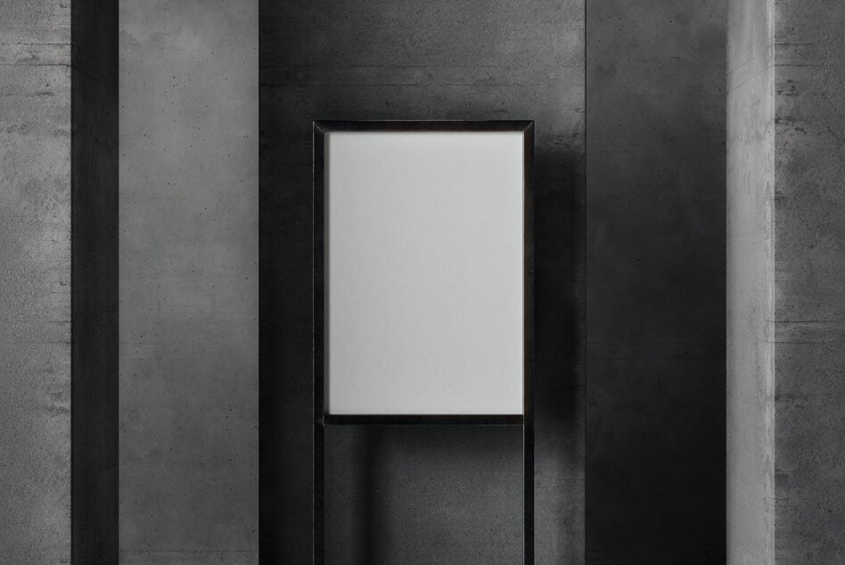 Minimalist concrete poster mockup with an empty white canvas on a modern dark grey wall. Ideal for showcasing graphic designs and templates for designers.