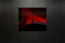 Video wall mockup with red gradient glow illuminating dark screens in grid formation