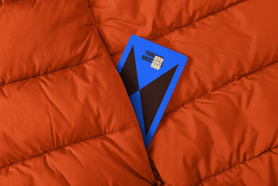 Blue card with geometric design peeks from the pocket of an orange quilted fabric; ideal for mockup, graphic design, digital assets, templates.