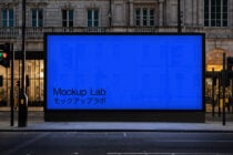 Street-level digital display on classical building facade showing blue background with Mockup Lab text