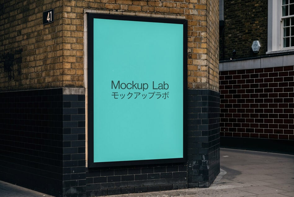 Turquoise illuminated lightbox mounted on brick corner exterior, Mockup Lab branding in two languages