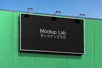 Bright lit signage on building facade with vibrant green wall mounting Mockup Lab