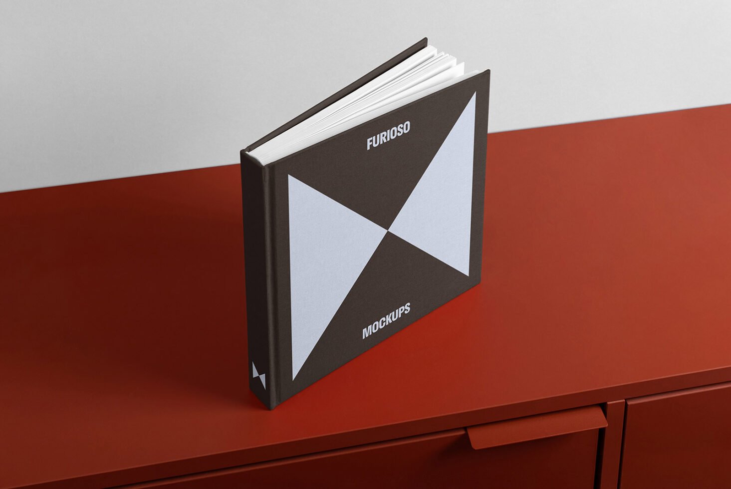 Hardcover book mockup on red surface showcasing front cover design with geometric pattern Ideal for designers graphics templates high-quality presentation