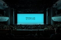 Full theater audience facing large cyan screen displaying Mockup Lab text