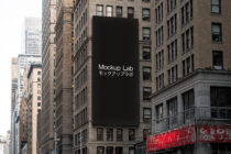 Tall building billboard mockup with black background between historic downtown structures