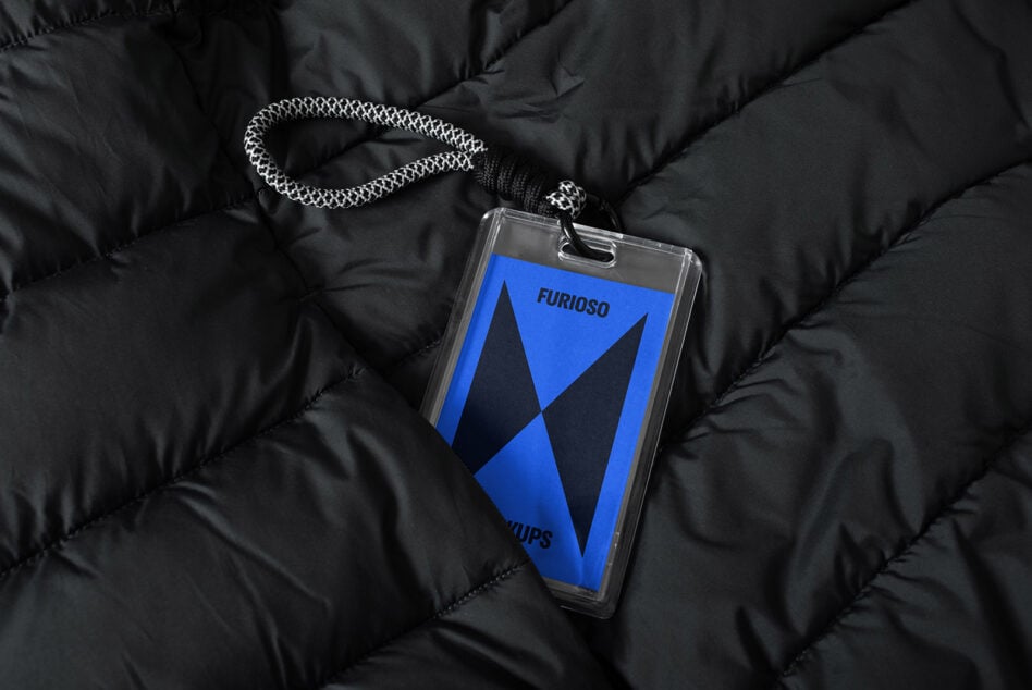 ID card mockup on black quilted fabric displaying a blue card with logo and text Furioso. Ideal for fashion designers and branding presentations.