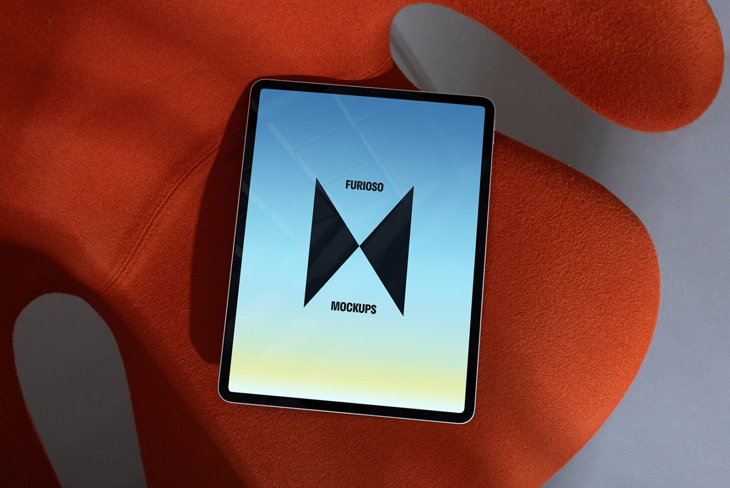 Tablet mockup placed on a modern orange fabric surface showcasing a stylish logo. Ideal for digital designers seeking high-quality mockup templates.