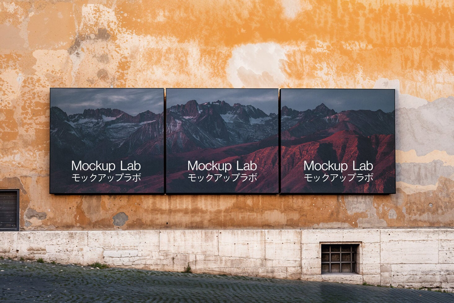 Three dark landscape photo panels on weathered peach-colored facade