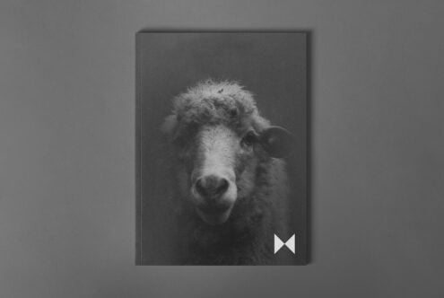 Notebook mockup with a monochrome sheep cover on a gray background ideal for designers. Showcases realistic texture and minimalistic style design.