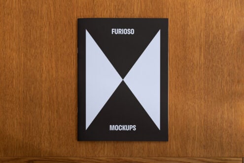 Mockup of a magazine cover on a wooden table featuring minimalist geometric design in black and white ideal for showcasing graphic design projects.