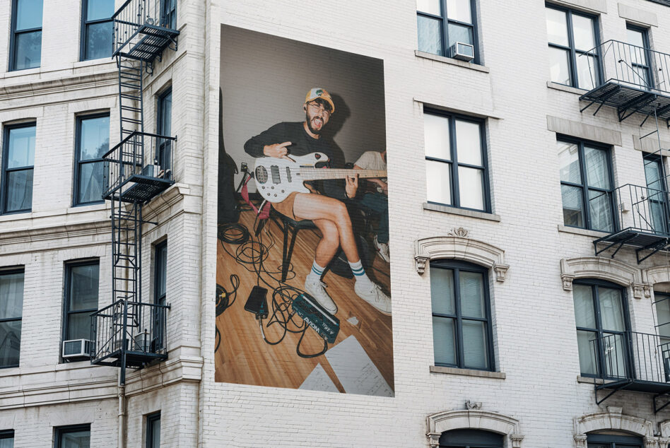 Oversized mural of musician with bass guitar on NYC building facade