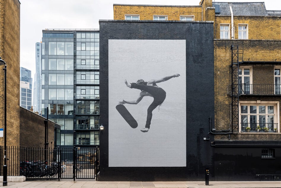 Urban wall mural featuring a black and white skateboarder performing a trick. Ideal for graphic designers and street art template enthusiasts.