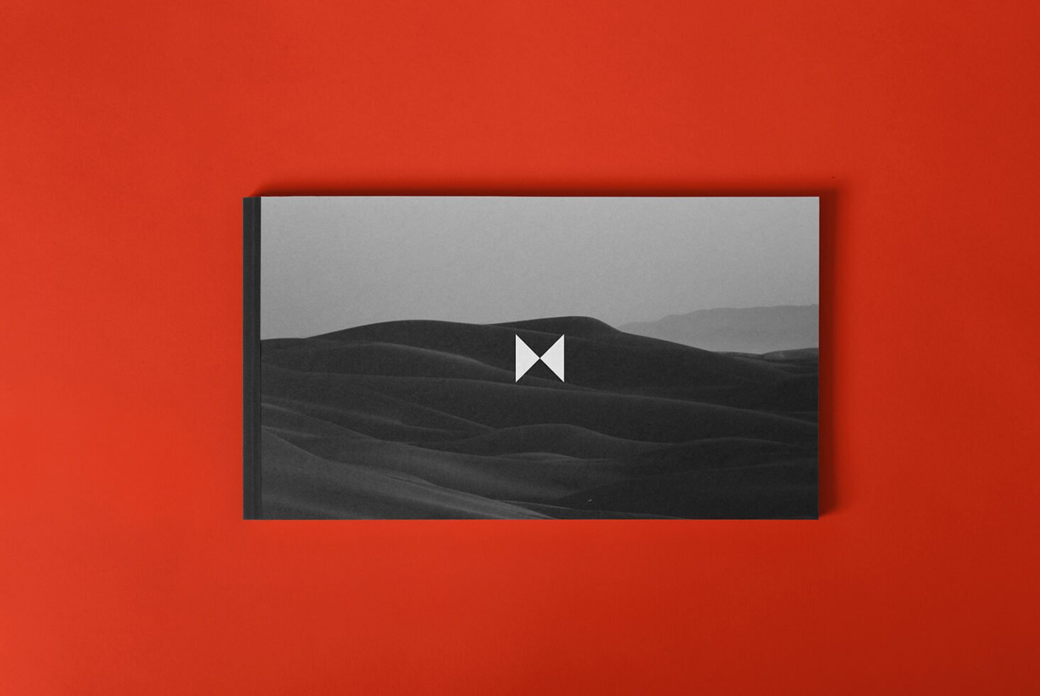 Black and white landscape photo on a book cover mockup against red background for graphic design presentations and portfolio showcases.