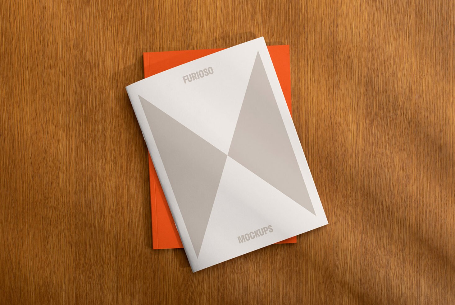 Magazine mockup with geometric cover design placed on an orange background on a wooden surface. Ideal for designers seeking modern print presentation.