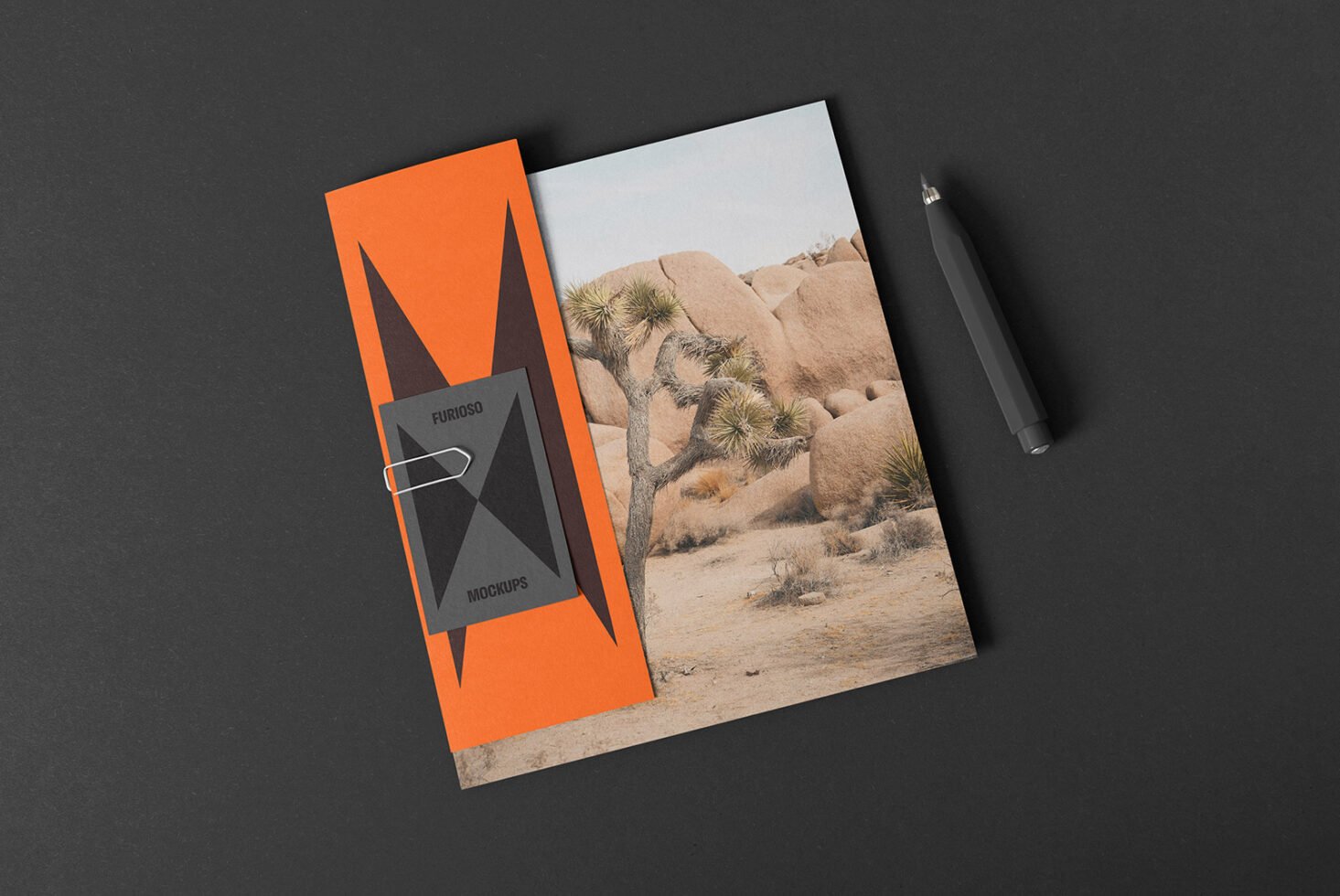 Mockup of an open folder on a dark surface with a desert landscape image and a sleek pen. Perfect for designers seeking presentation templates.