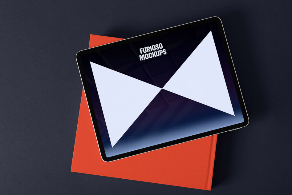 Tablet mockup displaying a geometric design with a red book on a dark surface. Ideal for digital designers seeking sleek presentation templates.