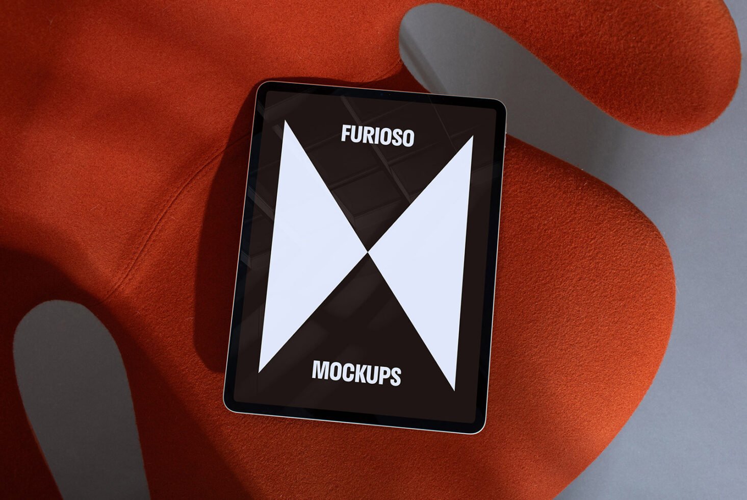 Tablet on modern orange chair with Furioso mockups display. Perfect for designers seeking sleek digital asset templates for creative projects.