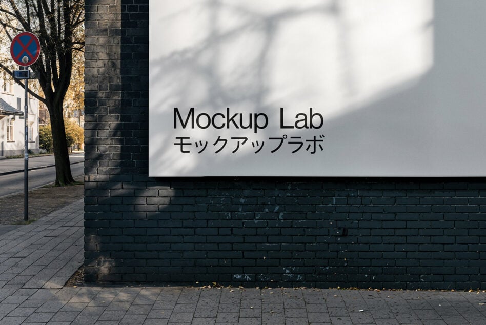 Street sign mockup on a black brick wall with bold minimalist typography. Ideal for designers showcasing branding ideas. SEO keywords: mockups, signage.