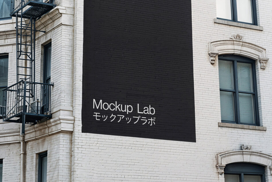 Black sign mounted on white building facade displaying Mockup Lab in white letters