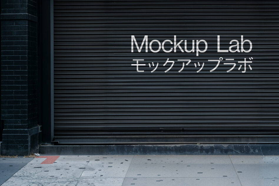 City storefront with closed black shutter displaying Mockup Lab text in English and Japanese. Perfect for mockup design, urban scene template.