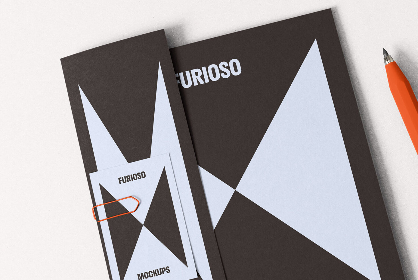 Stationery mockup with geometric designs on dark paper, showcasing branding elements. Includes a pen and a paperclip. Ideal for graphic design projects.