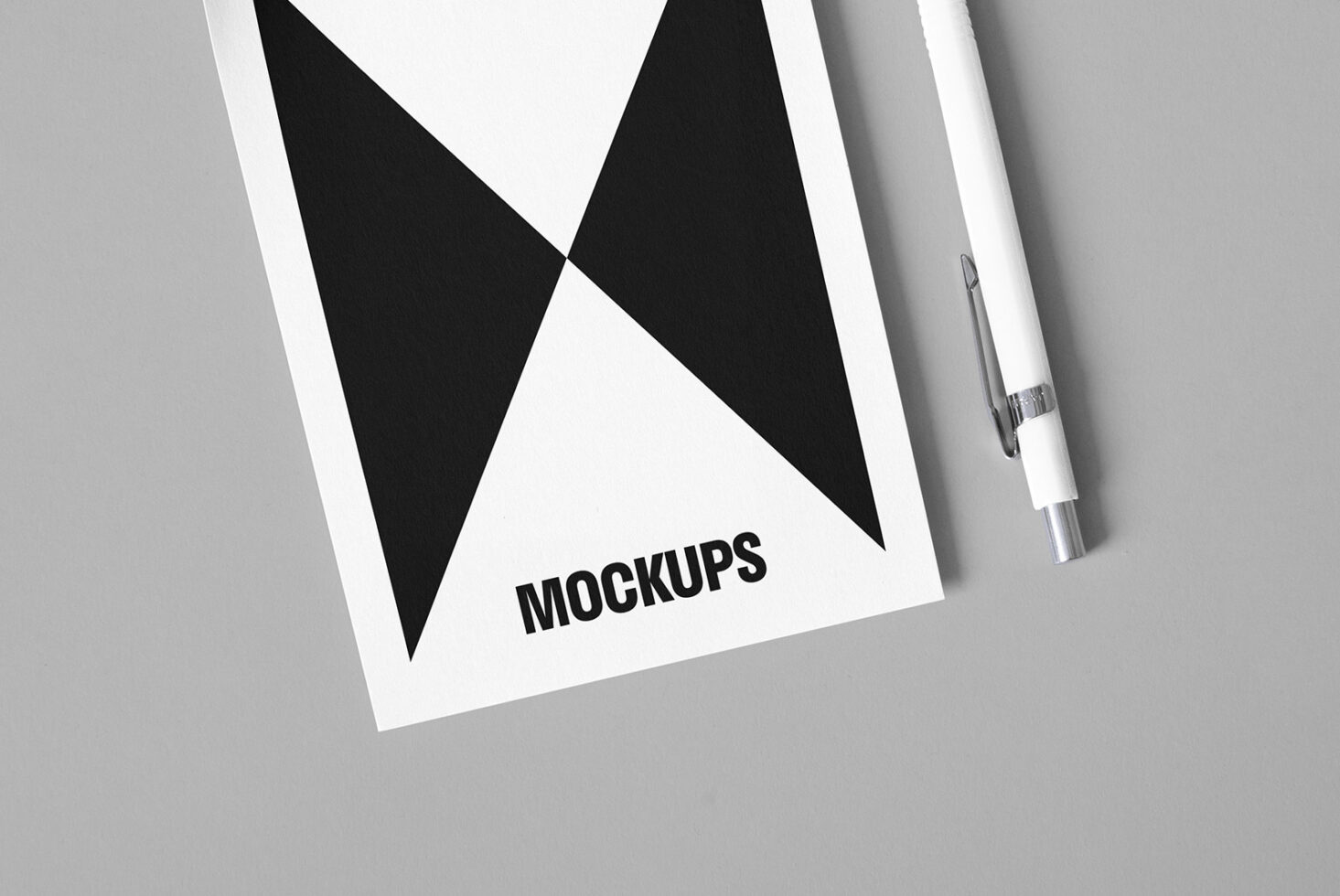 Minimalist mockup template featuring geometric black and white design on paper with pen. Ideal for designers seeking modern, sleek mockups in graphics.
