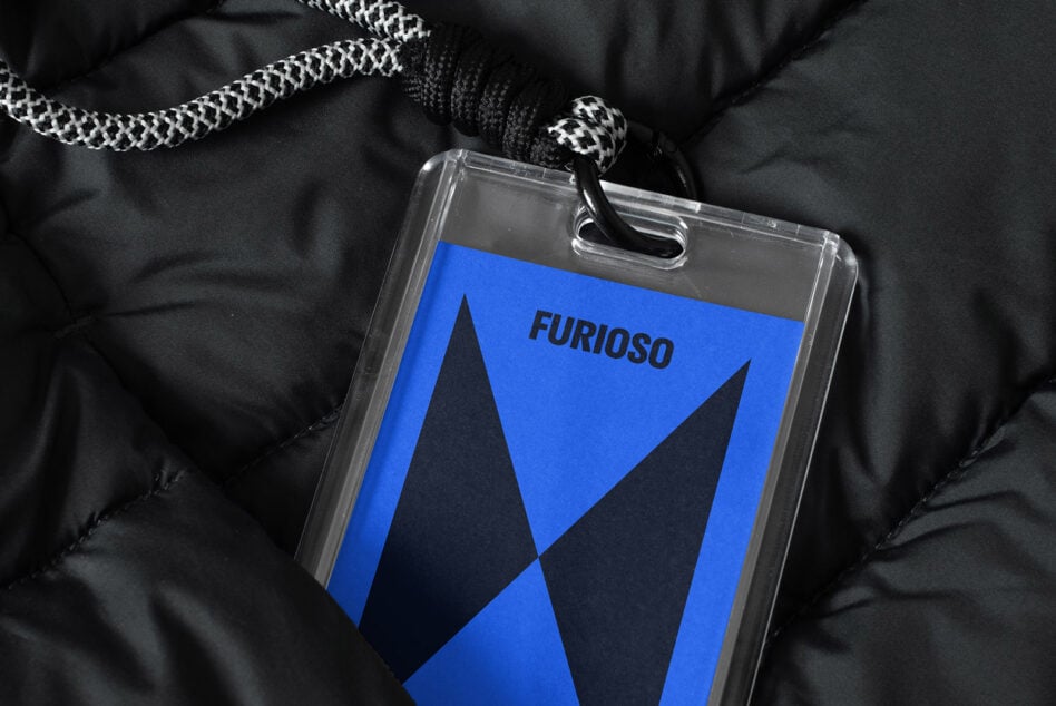 Blue badge mockup with bold black geometric design hanging on a quilted fabric, ideal for graphic designers, branding, templates, and identity showcase.