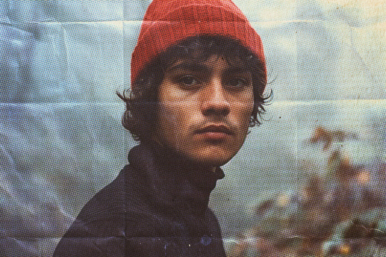 Vintage halftone portrait of a person wearing a red beanie. Ideal for digital graphics, photo effects, retro design resources. Perfect for designers.