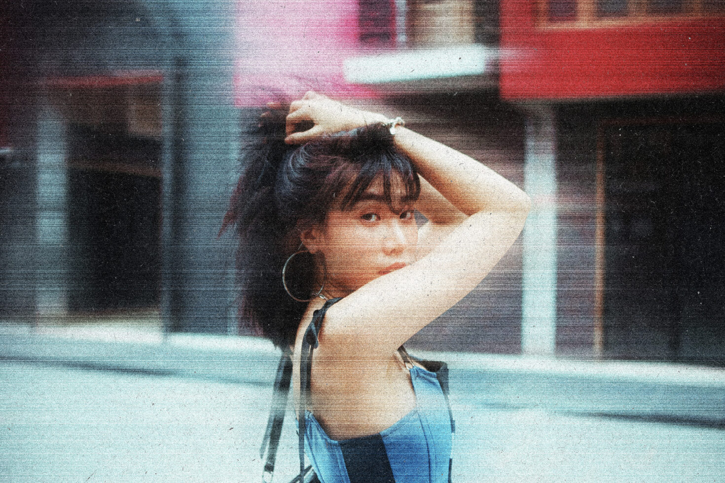Stylized urban portrait of a woman in a denim outfit with vintage texture effect showcasing street fashion ideal for graphics and design inspiration.