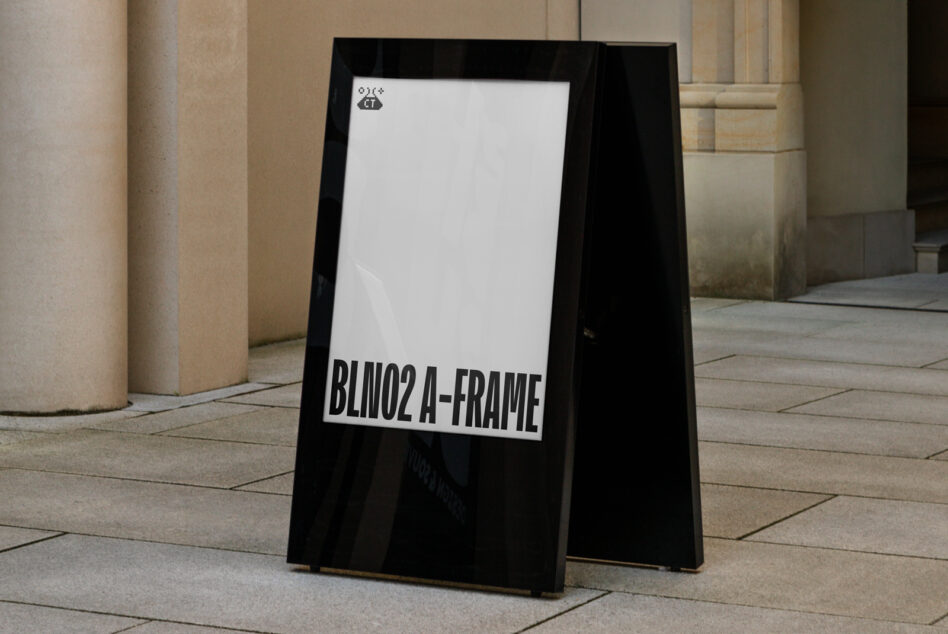 Double-sided A-frame sign with white text on black background in architectural courtyard