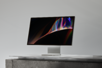 Modern computer monitor mockup on concrete surface featuring abstract digital graphics perfect for designers showcasing projects or advertising templates