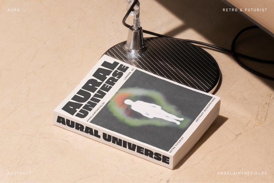 Retro book cover Aural Universe on a beige floor next to a metal lamp base. Keywords: mockup, abstract, graphic design, book cover, retro, futurist