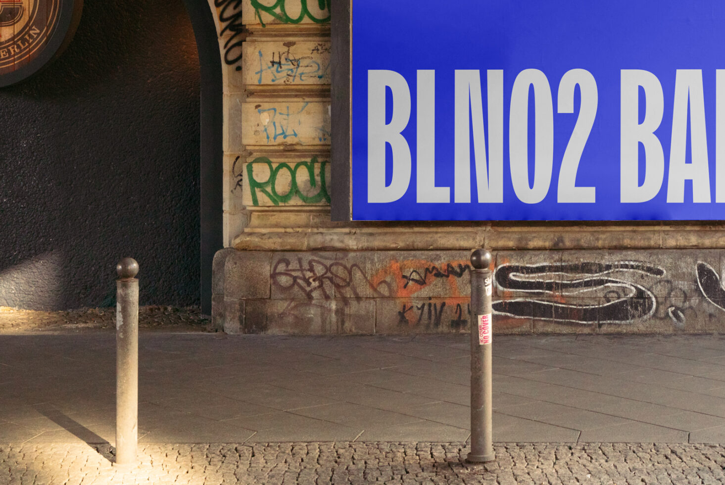 Urban scene with a large blue mockup billboard. Graffiti-covered wall, vintage architecture. Ideal for designers targeting street art and urban design projects.