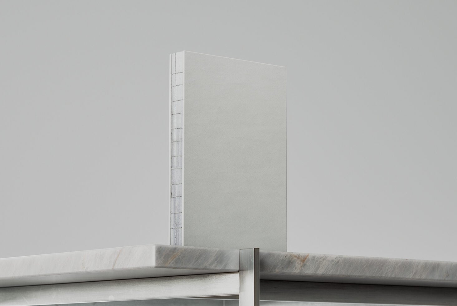 White hardcover book with spiral binding on marble surface
