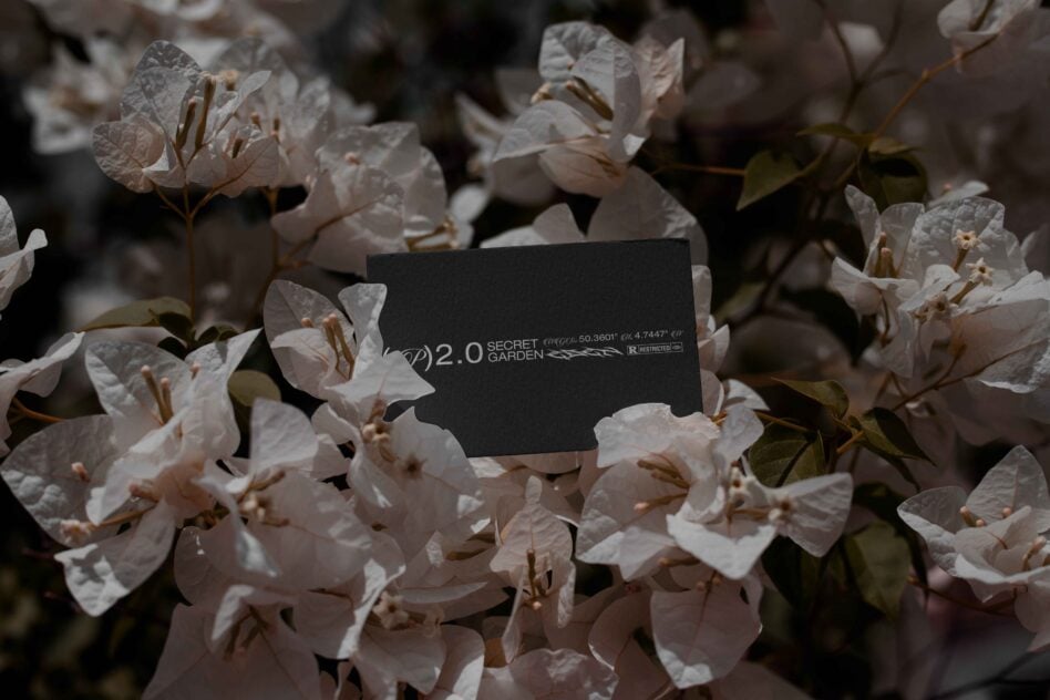 Dark business card with Secret Garden 2.0 branding surrounded by soft pink flowers