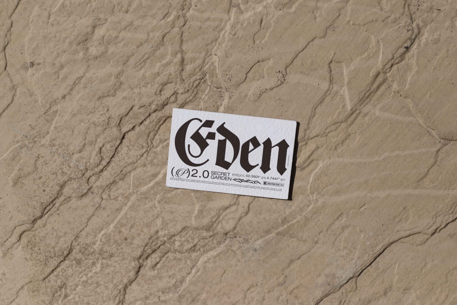 White business card featuring 'Eden' design laid on sand with natural lines