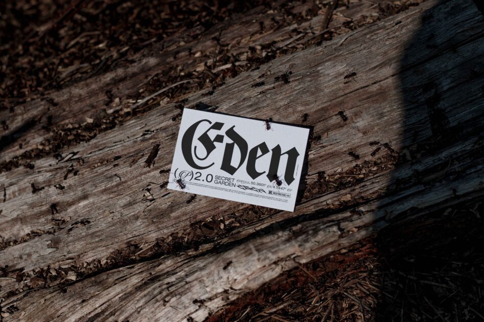 White business card with 'Eden' bold lettering on textured wood surface